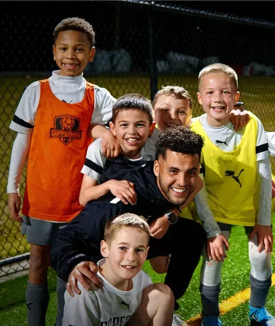Coppermine Soccer Club's coach surrounded by happy youth club soccer players. Coppermine Soccer Club's coach surrounded by happy youth club soccer players.
