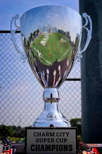 Silver trophy with a green field reflection and plaque reading “Charp City Super Cup Champions.”