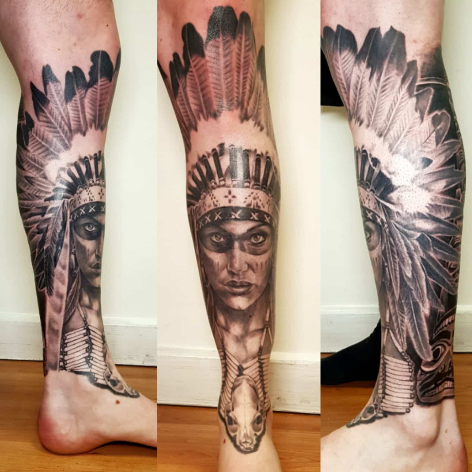 A black and grey tattoo on a person's lower leg depicting a figure in a traditional feathered headdress.