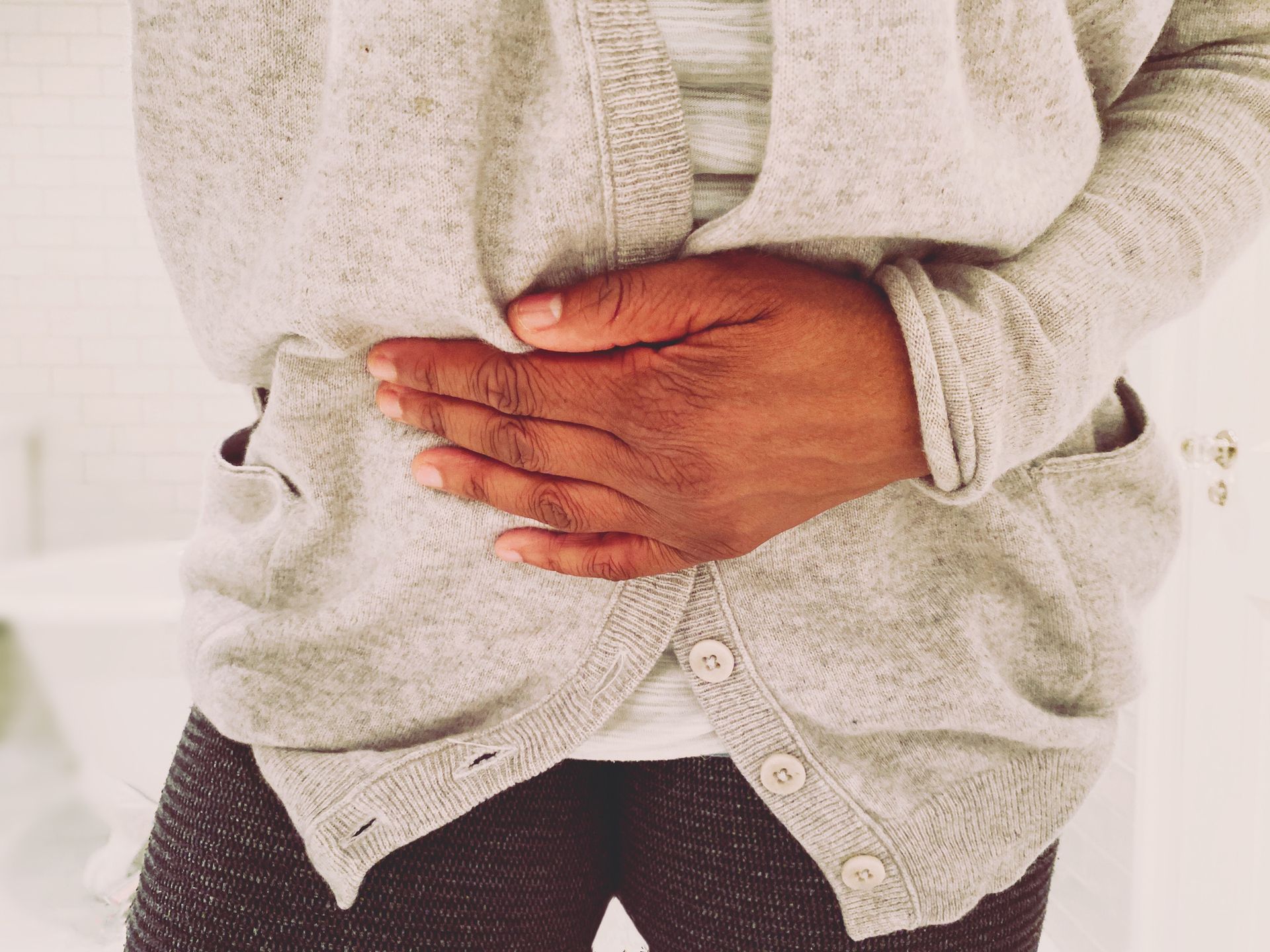 A Woman is Holding her Stomach in Pain — Orlando, FL — Central Florida Kidney Specialists A Woman is Holding her Stomach in Pain — Orlando, FL — Central Florida Kidney Specialists