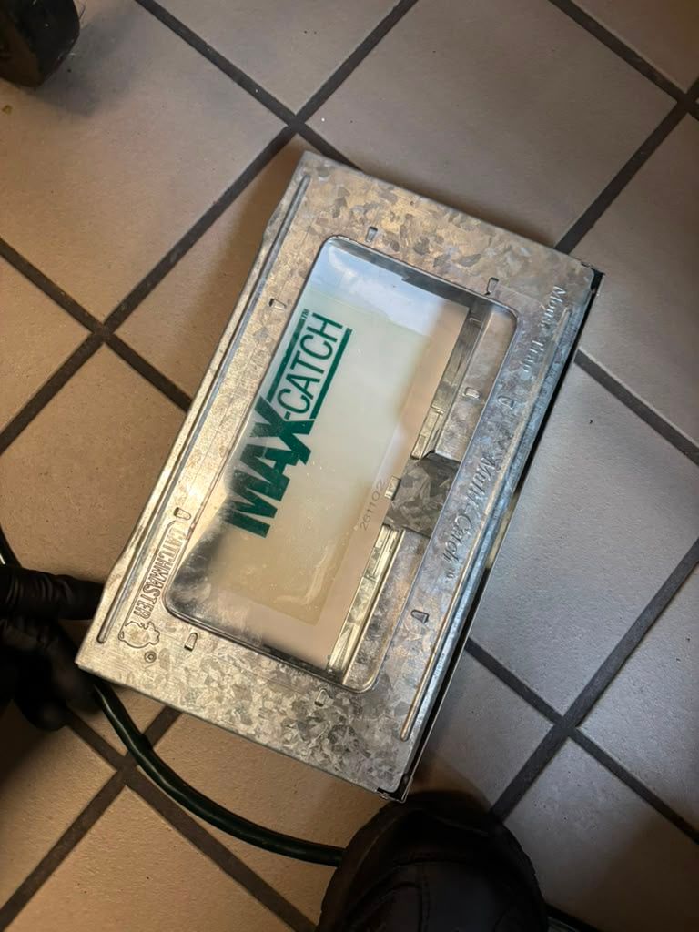 A metallic pedal case on a tiled floor with a clear window labeled “MAXMATCH.”