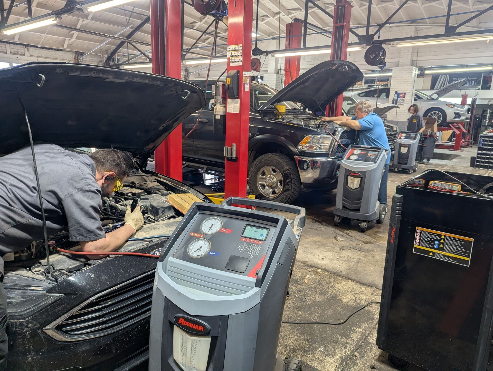 Auto repair shop with cars on lifts and mechanics working under open hoods