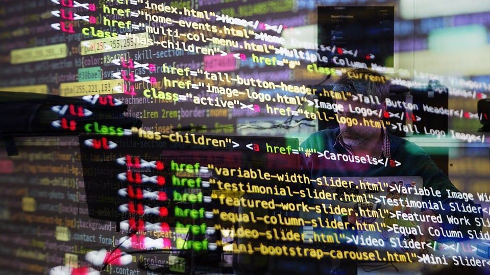 Colorful code lines overlaid on a blurred computer screen, suggesting web development or programming