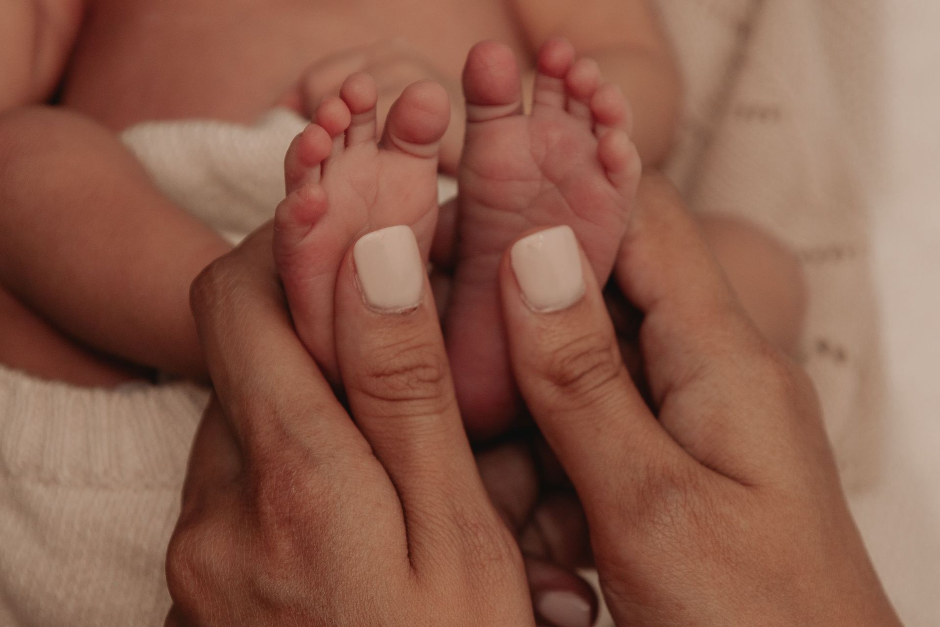 woman holding baby feet