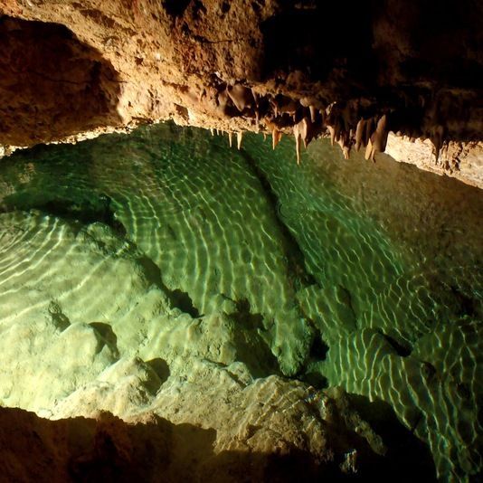 Una gran bassa d'aigua verda en una cova