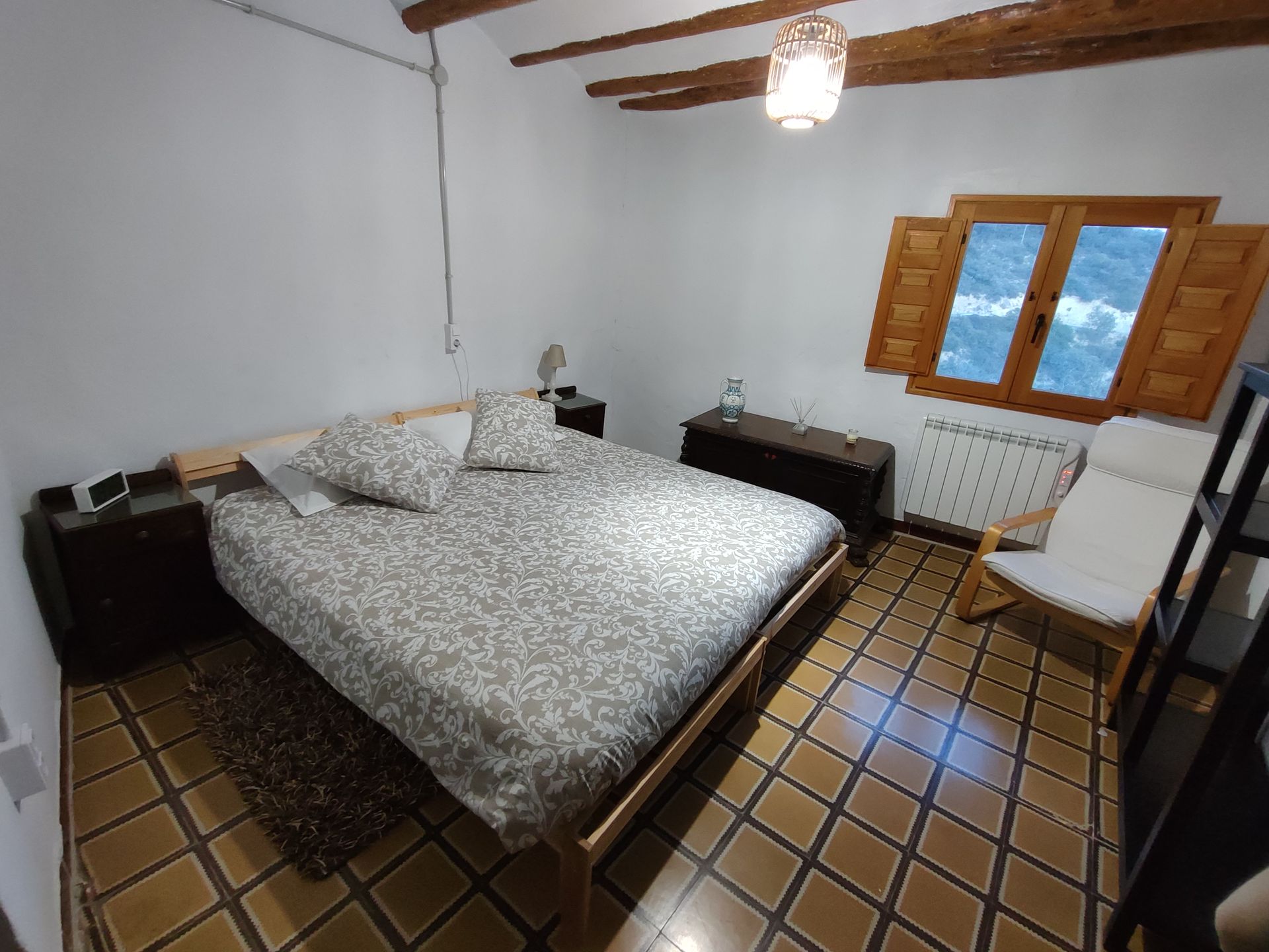 Un dormitori amb un llit i una cadira