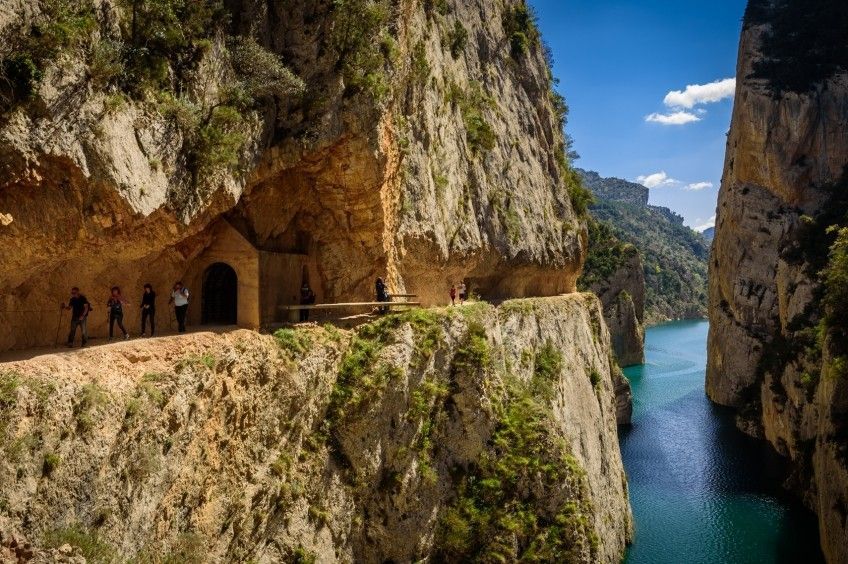 Un grup de persones està dret en un penya-segat amb vistes a un riu.