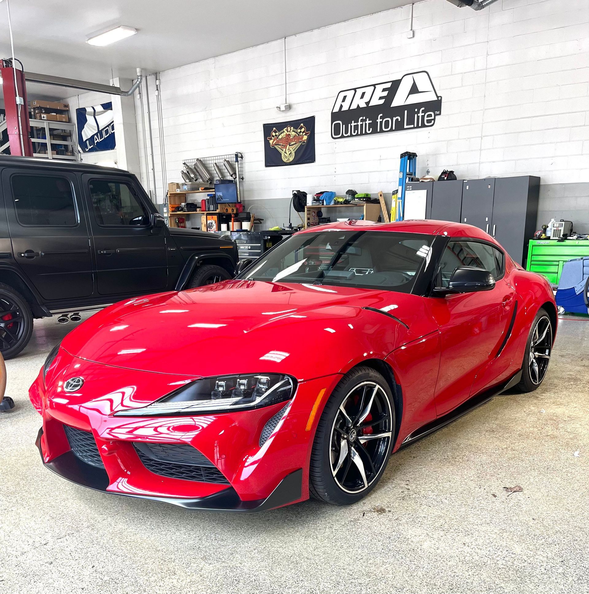 A red toyota supra is parked in a garage