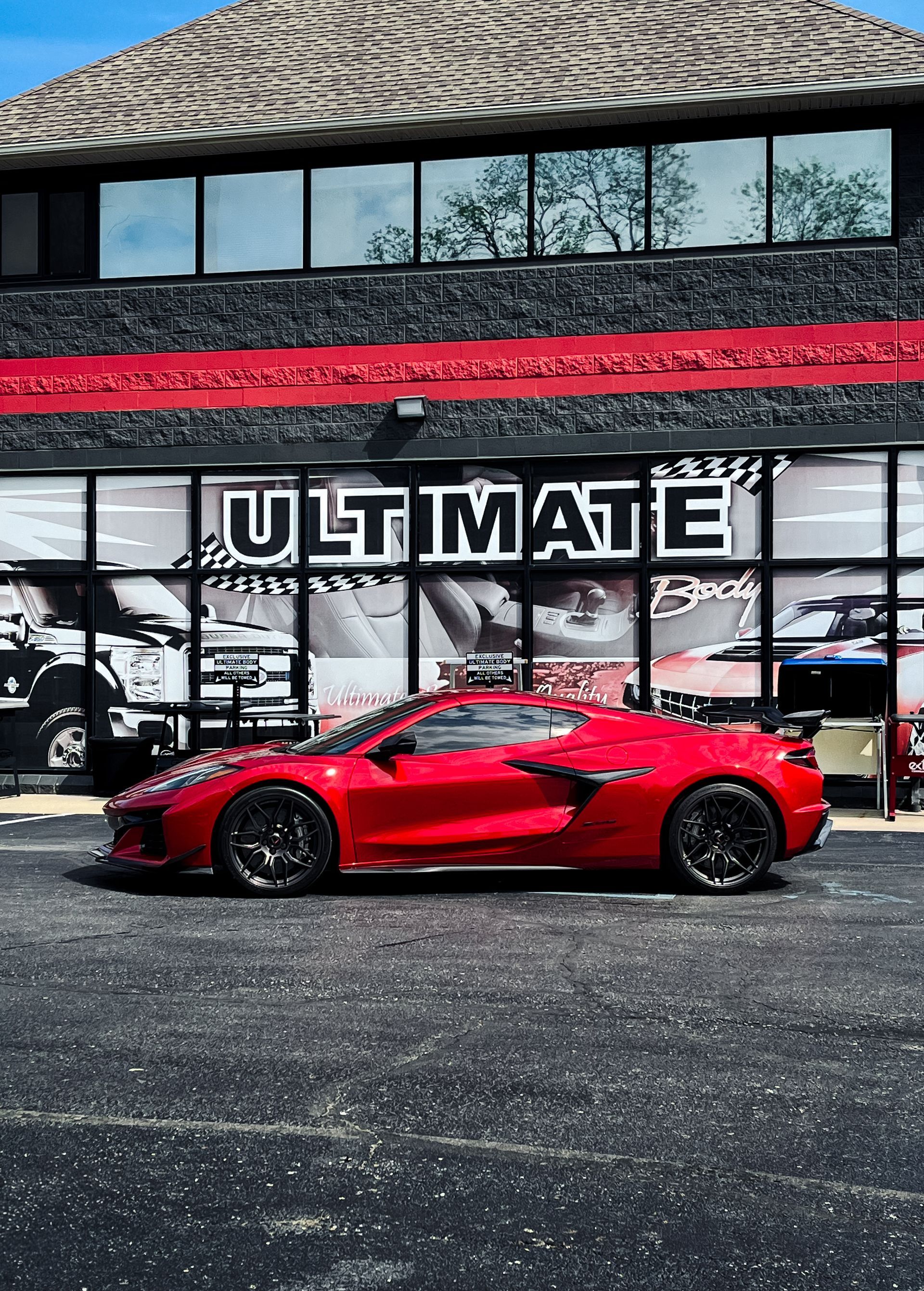 A white sports car with a spoiler is parked in a parking lot.