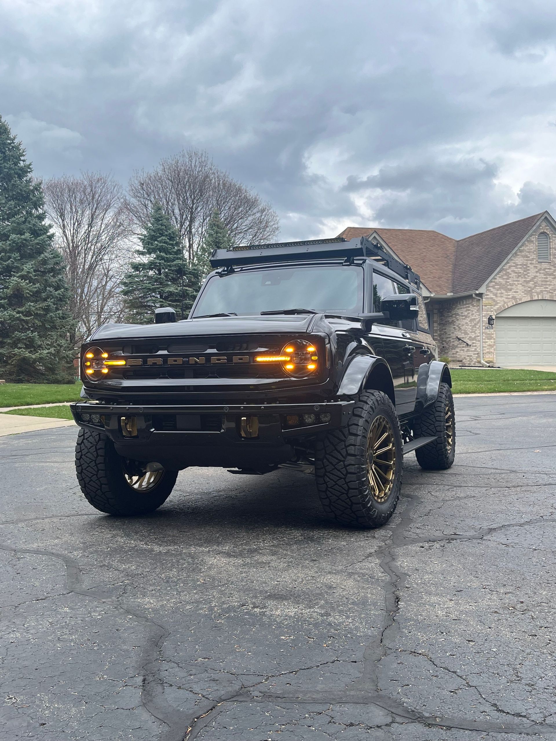 A black truck is parked in a driveway in front of a house.