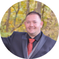 A man in a suit and tie is smiling in a circle.