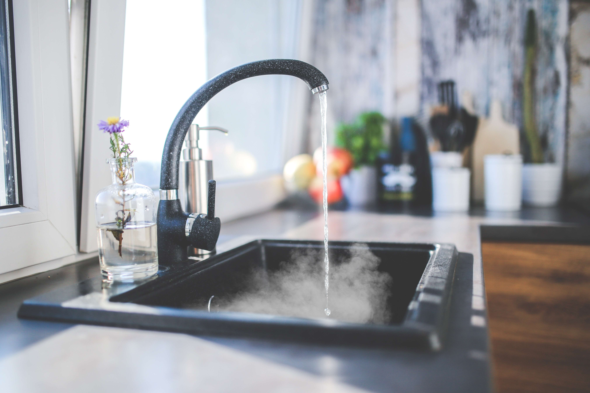 A kitchen sink with water running from the faucet.