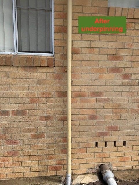 Brick wall of a house with a visible crack and a green “After underpinning” label.