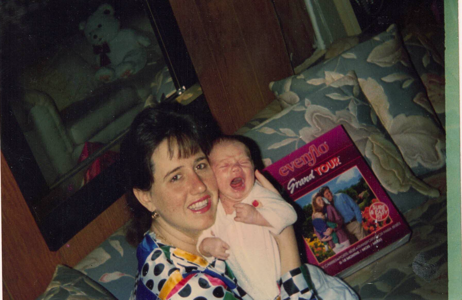 A woman is holding a baby in front of a book that says evergla friend visit