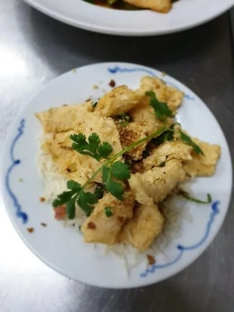 Fried Dish Over Rice on a Plate, Garnished With Cilantro — L'il Buddha Asian Cuisine in Salamander Bay, NSW