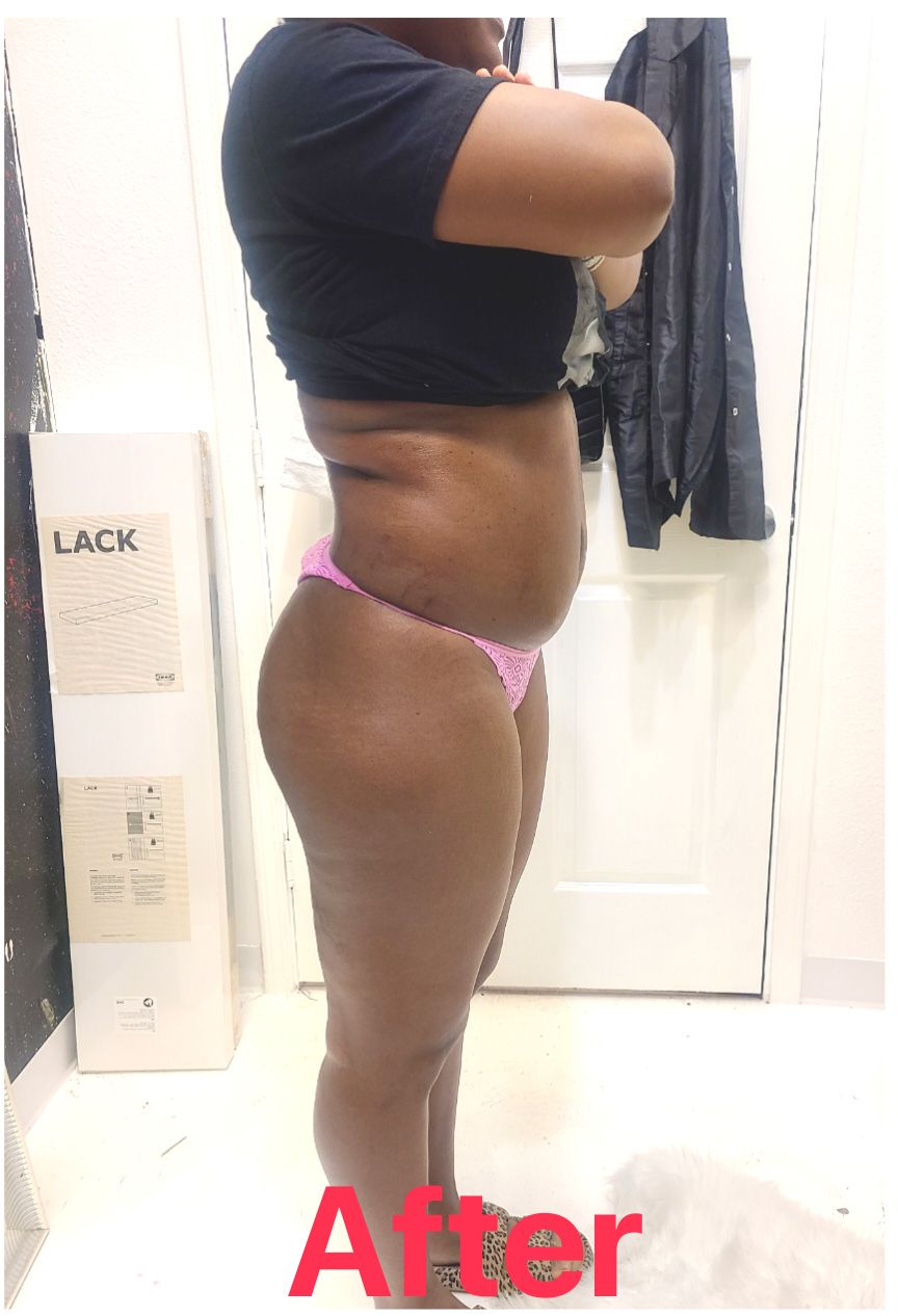 A woman in a black shirt and pink underwear is standing in a bathroom.