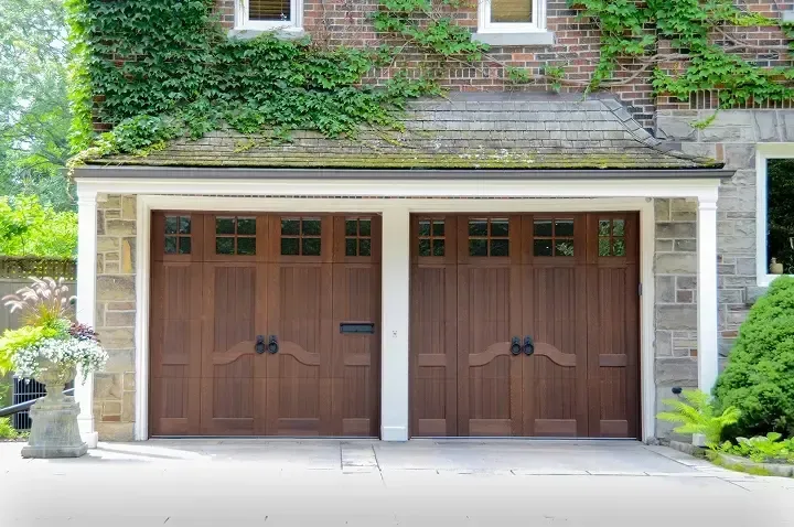A large house with two garage doors and a brick facade.
