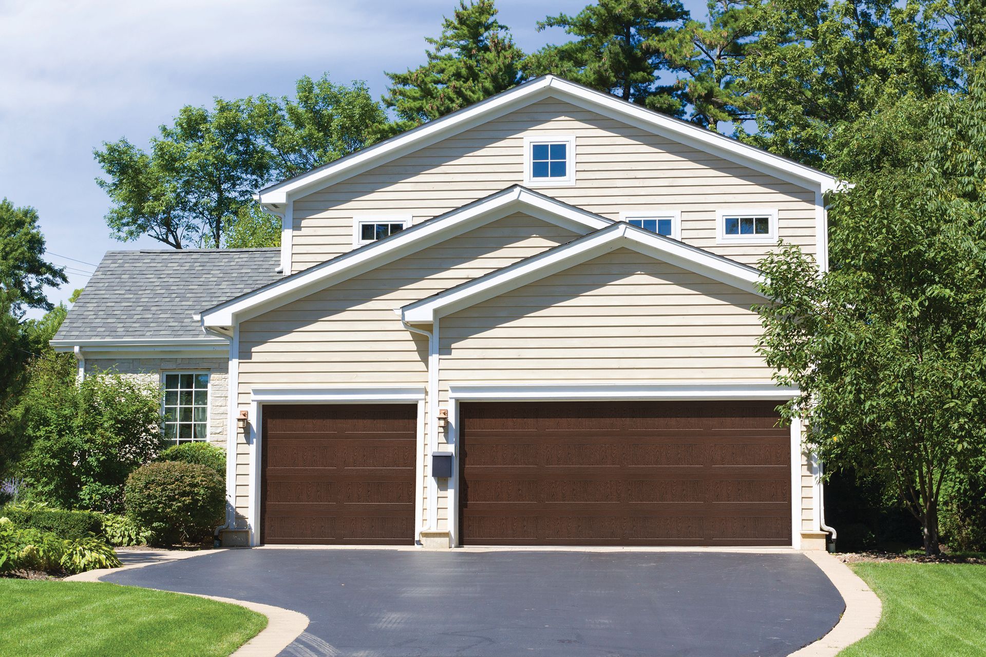 A large house with two garage doors and a driveway