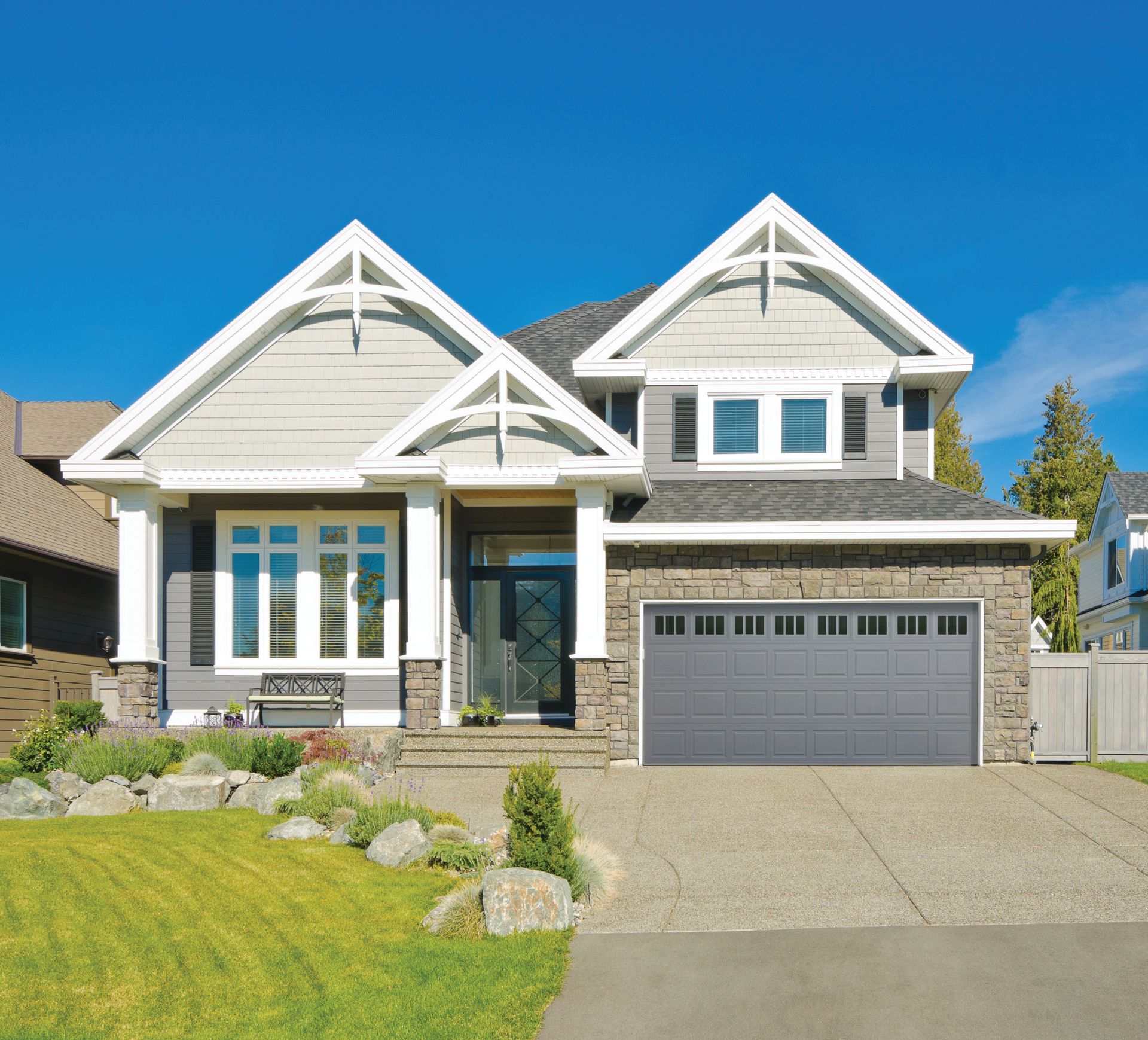 A large white house with a gray garage door