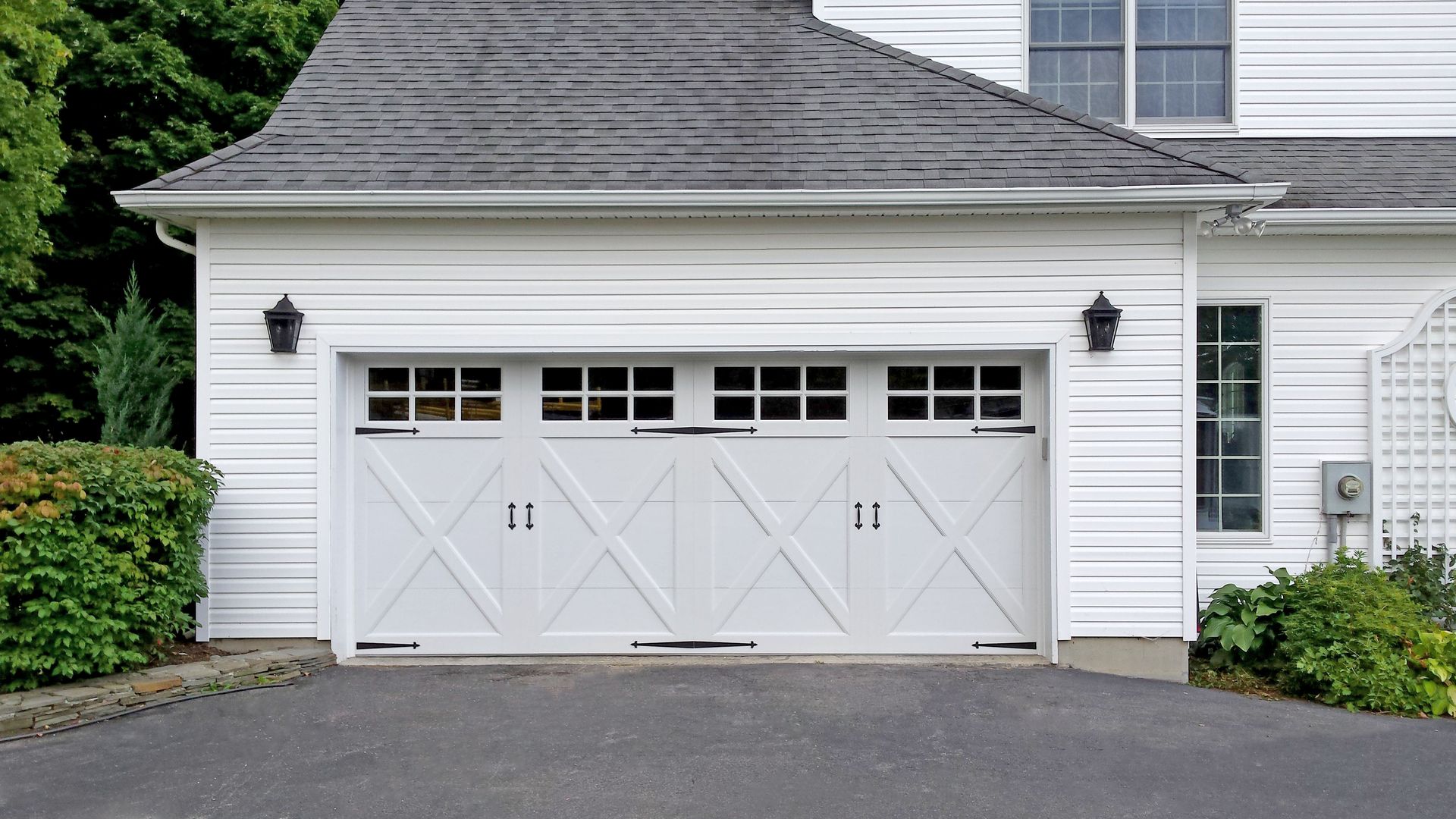A house with two garage doors and a large window.