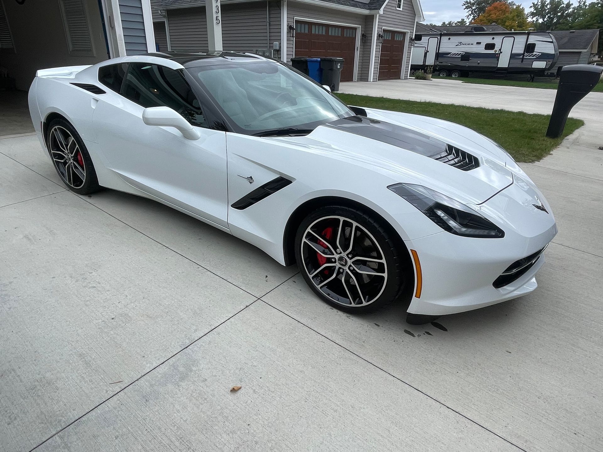 White sports car parked in a driveway in front of a house