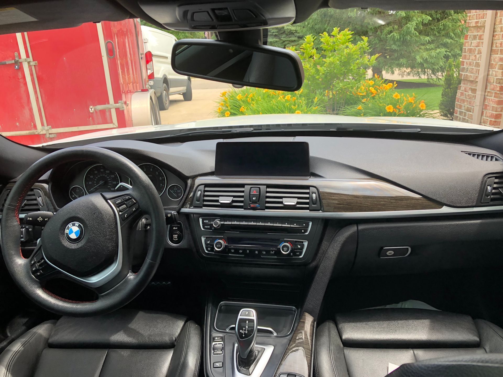 BMW car interior viewed from the driver’s seat, with dashboard, steering wheel, and center console visible