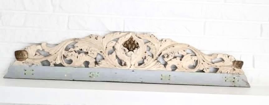 Beige carved decorative relief with swirling floral shapes on a light blue base