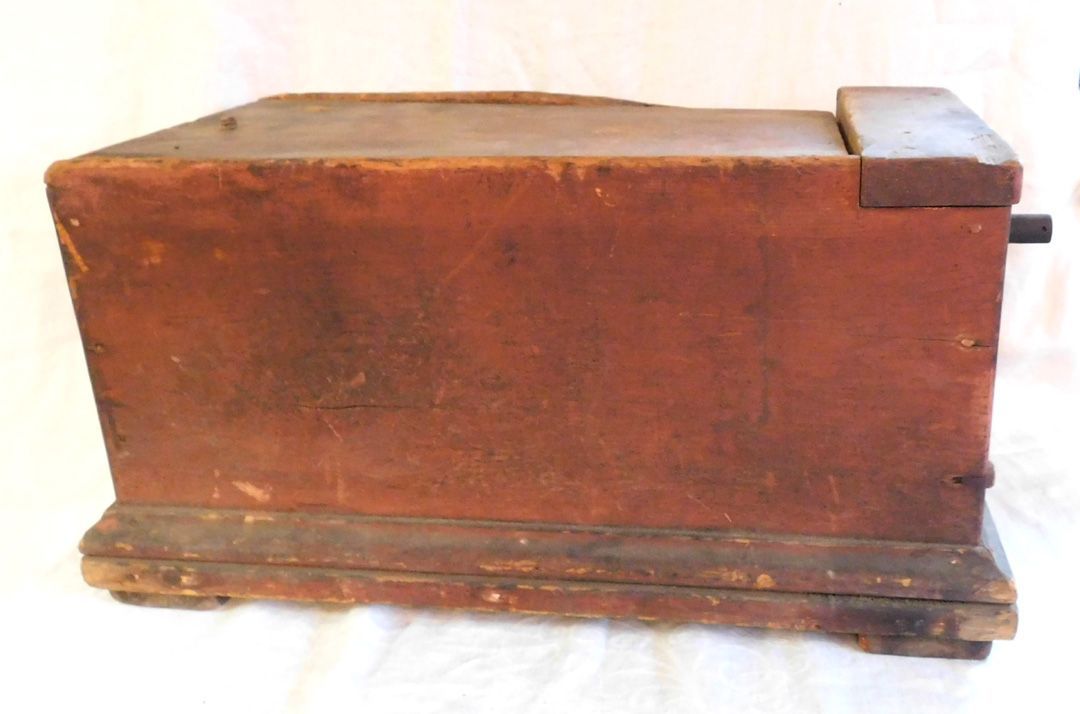 Old wooden box with a weathered base and small metal cap on the right side