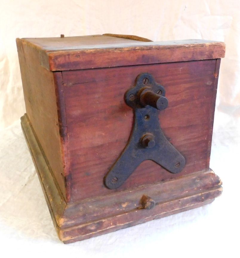 Old wooden box with a weathered base and small metal cap on the right side