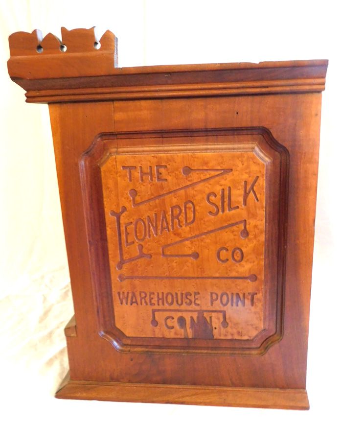 Wooden Leonard Silk Co. warehouse point crate label with carved top edge and faded painted text