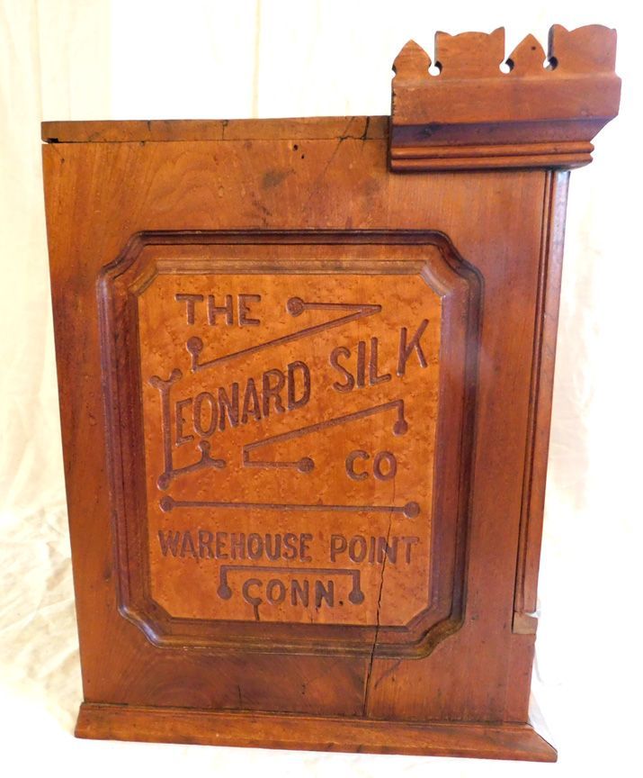 Wooden Leonard Silk Co. warehouse point crate label with carved top edge and faded painted text