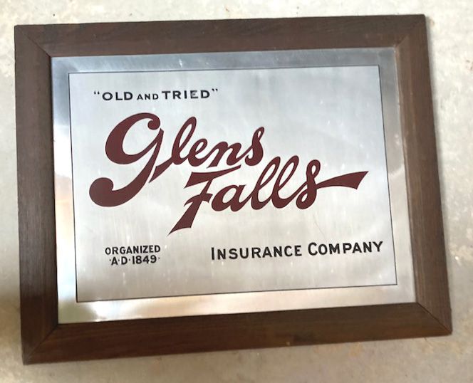 Framed Glens Falls Insurance Company sign with red script on white background