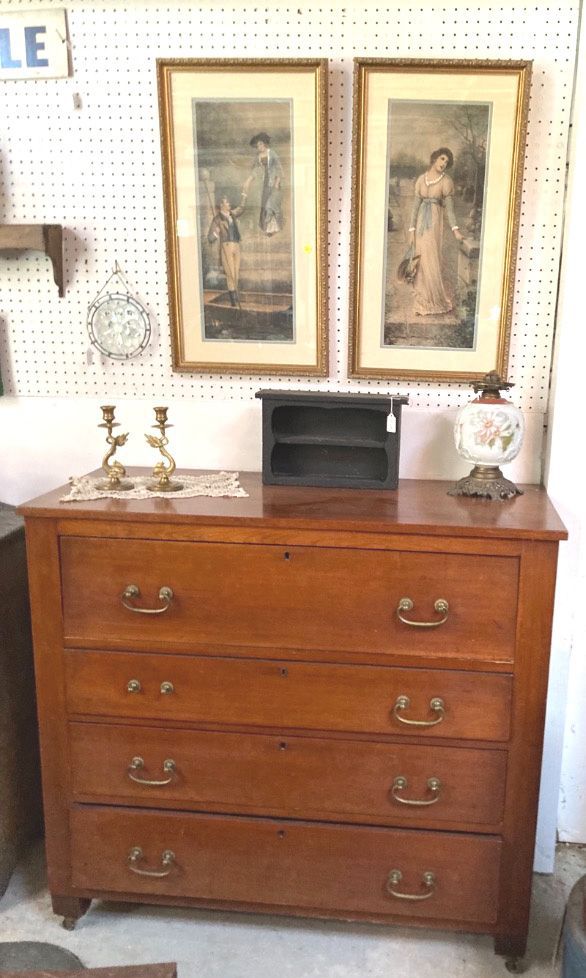 Wooden dresser with lamps and framed art above it in a vintage-style room