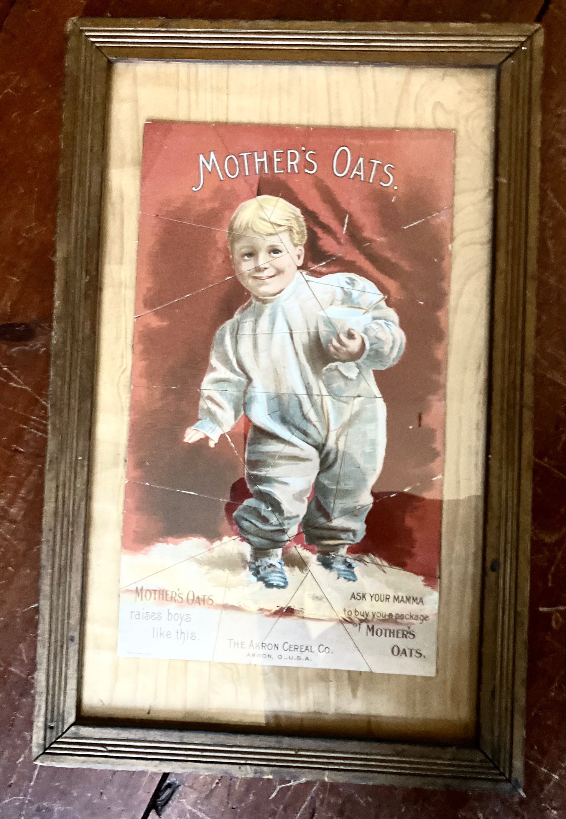 Framed vintage “Mother’s Oats” ad showing a smiling child in a white outfit on a red background