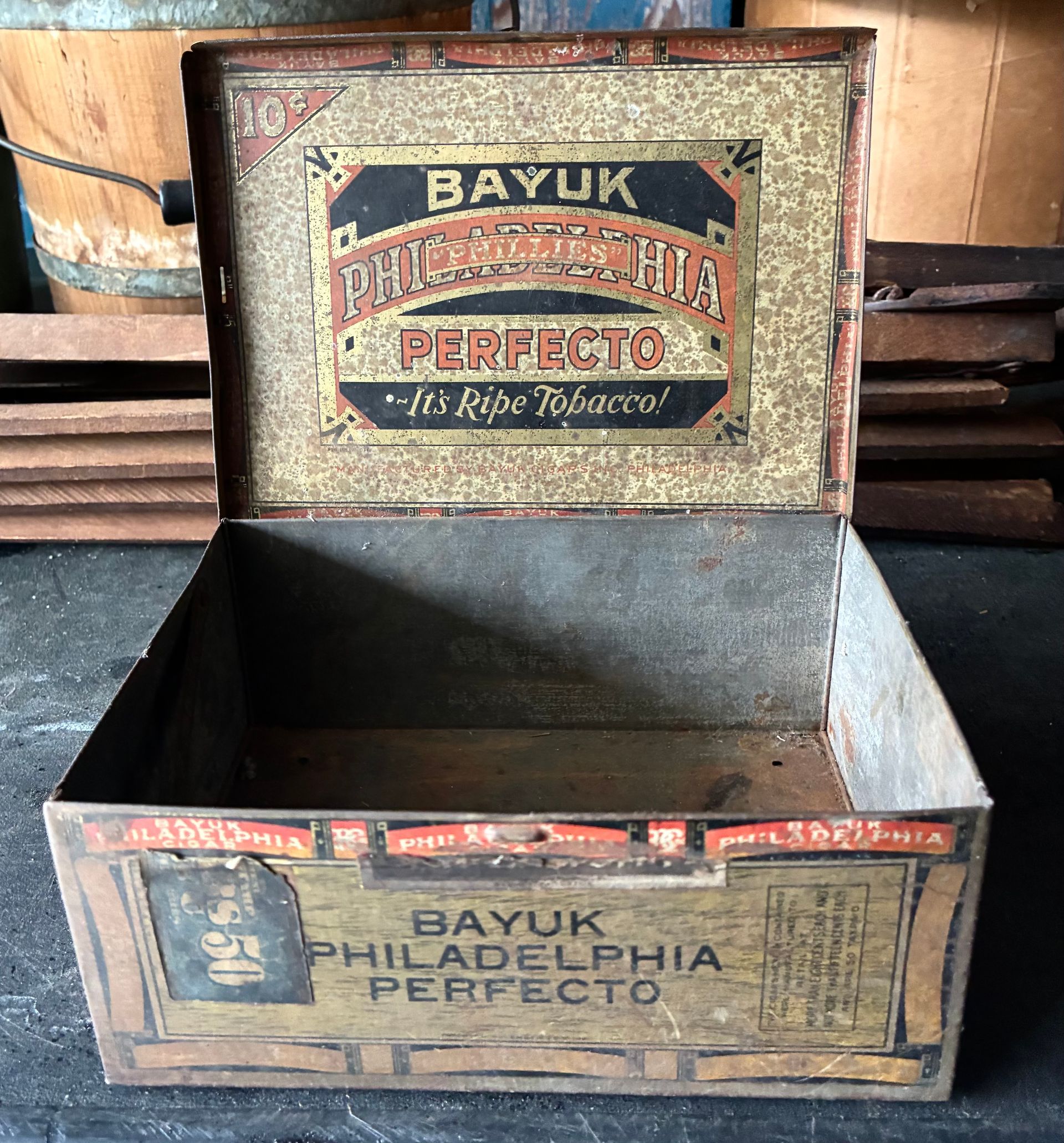 Open Bayuk Philadelphia Perfecto cigar box, vintage tin with worn red and gold label, empty inside