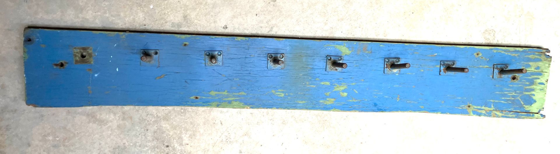 Blue wall-mounted strip with several small metal fixtures