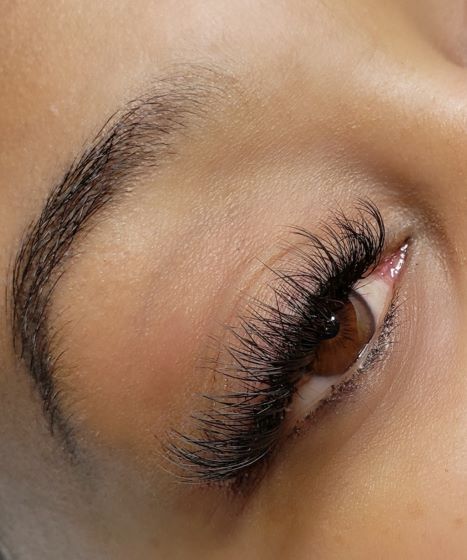 A close up of a woman 's eye with long eyelashes.