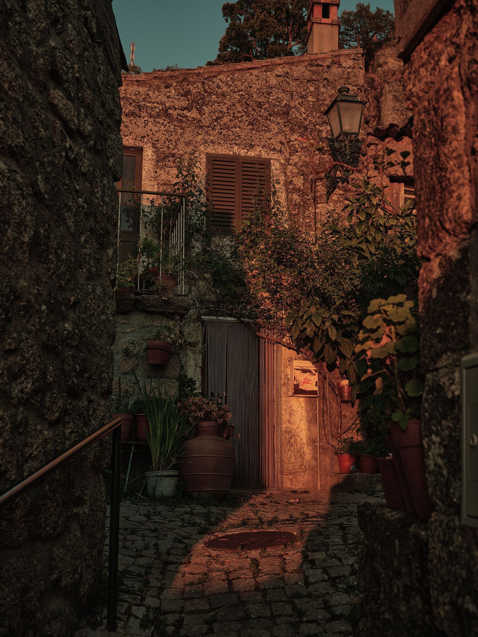 A narrow alleyway between two stone buildings at sunset