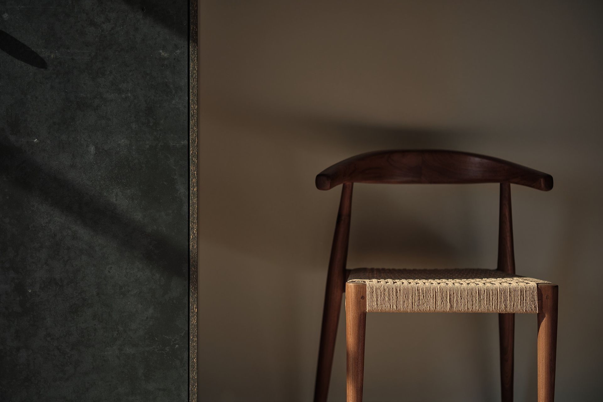 A wooden chair is sitting in front of a wall.