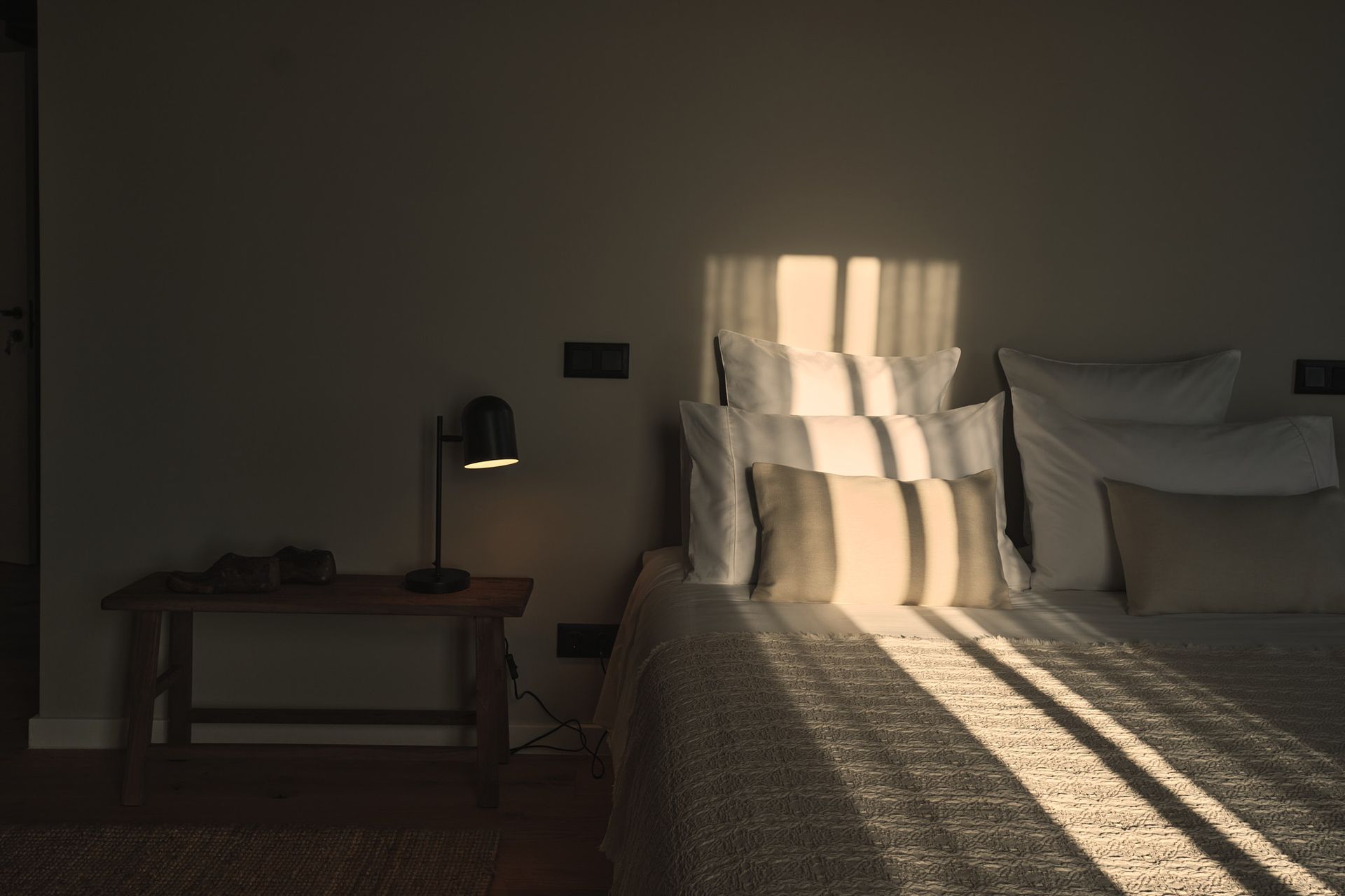 The sun is shining through the window on the bed.