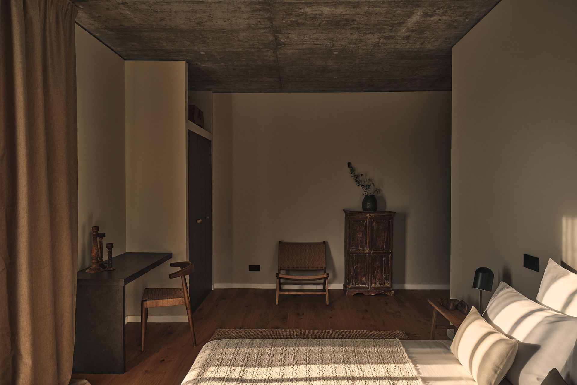 A bedroom with a bed , chair , desk and dresser.