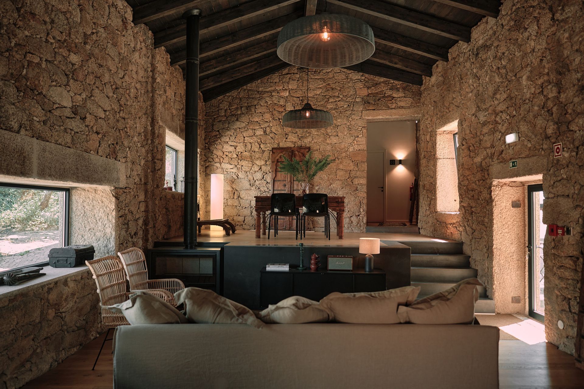 A living room filled with furniture and a stone wall.