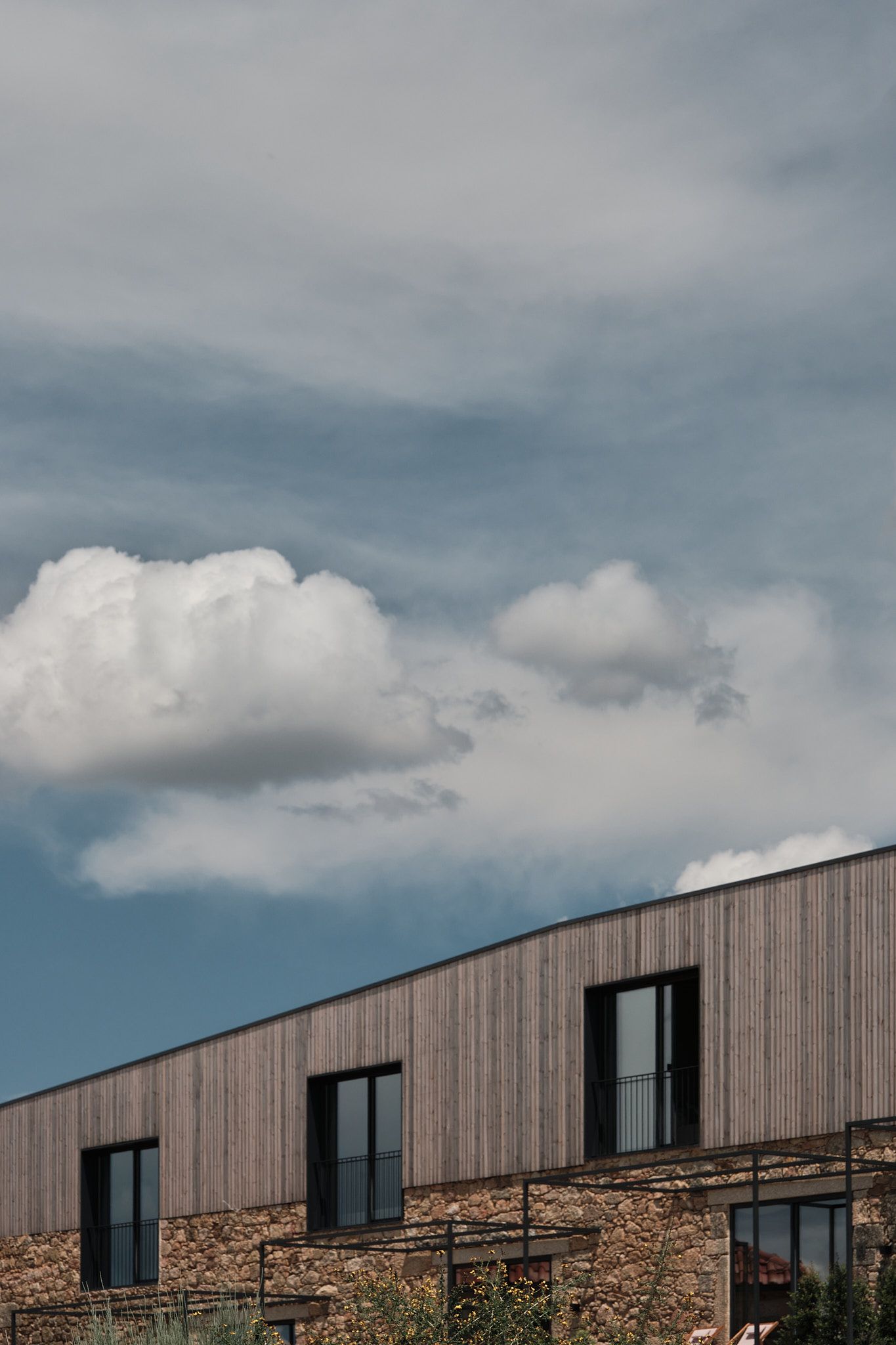 A building with a lot of windows and a cloudy sky in the background