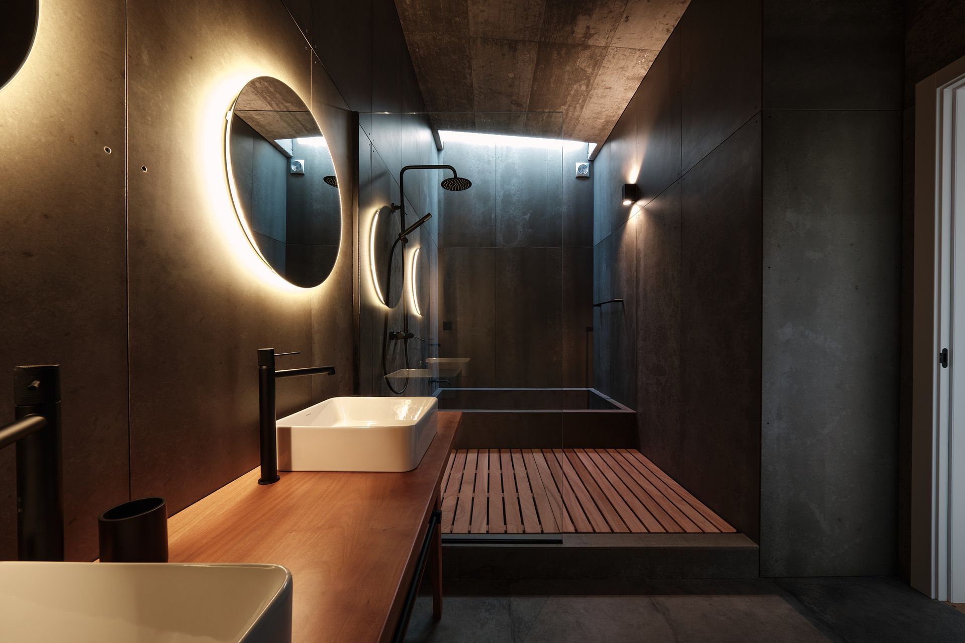 A bathroom with two sinks , a mirror and a bathtub.