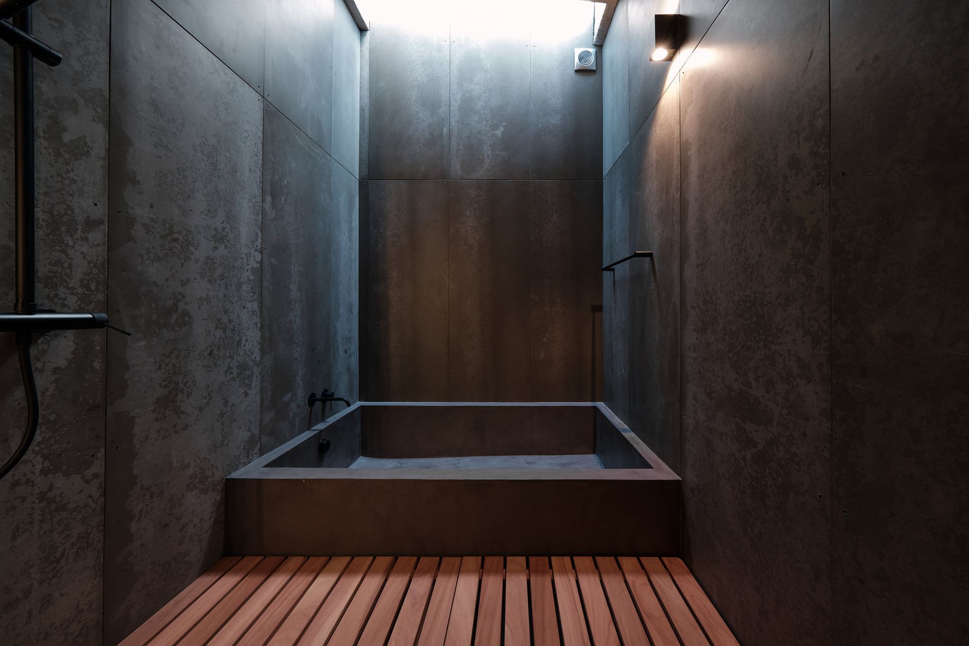 A bathroom with a bathtub and a wooden floor.