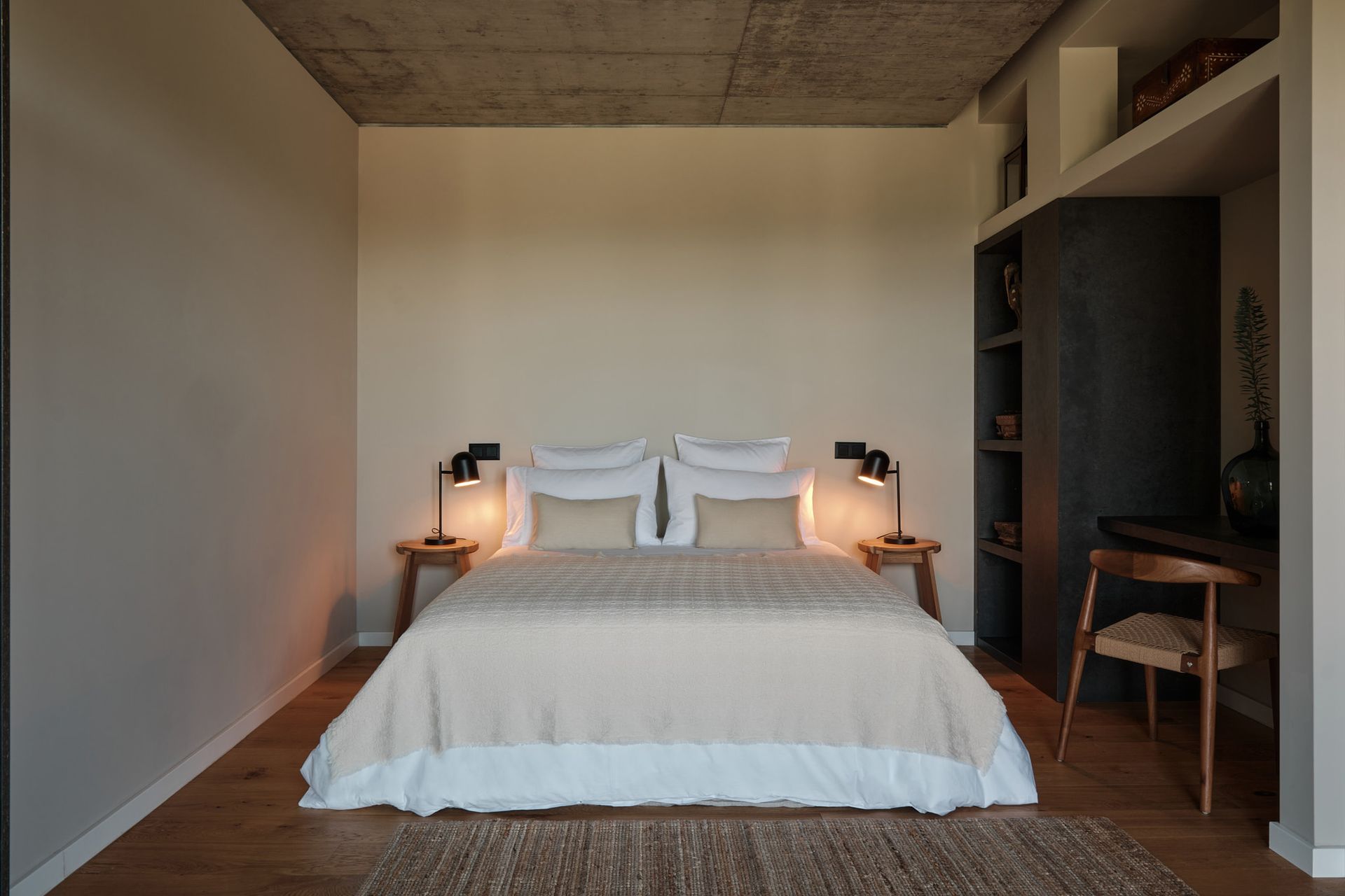 A bedroom with a large bed and a desk