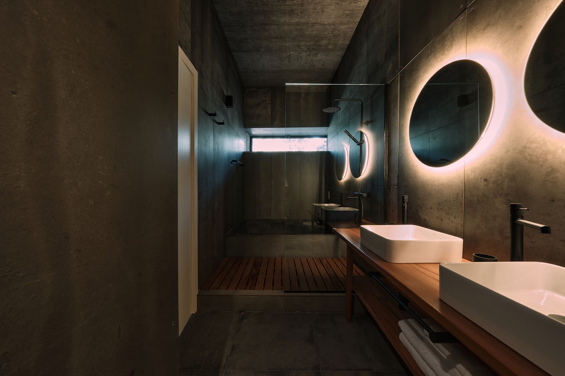 A bathroom with two sinks , a mirror and a shower.