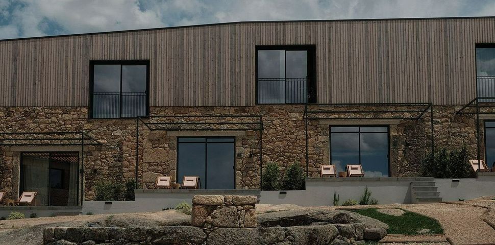 An artist 's impression of a brick house with wooden siding and sliding glass doors.