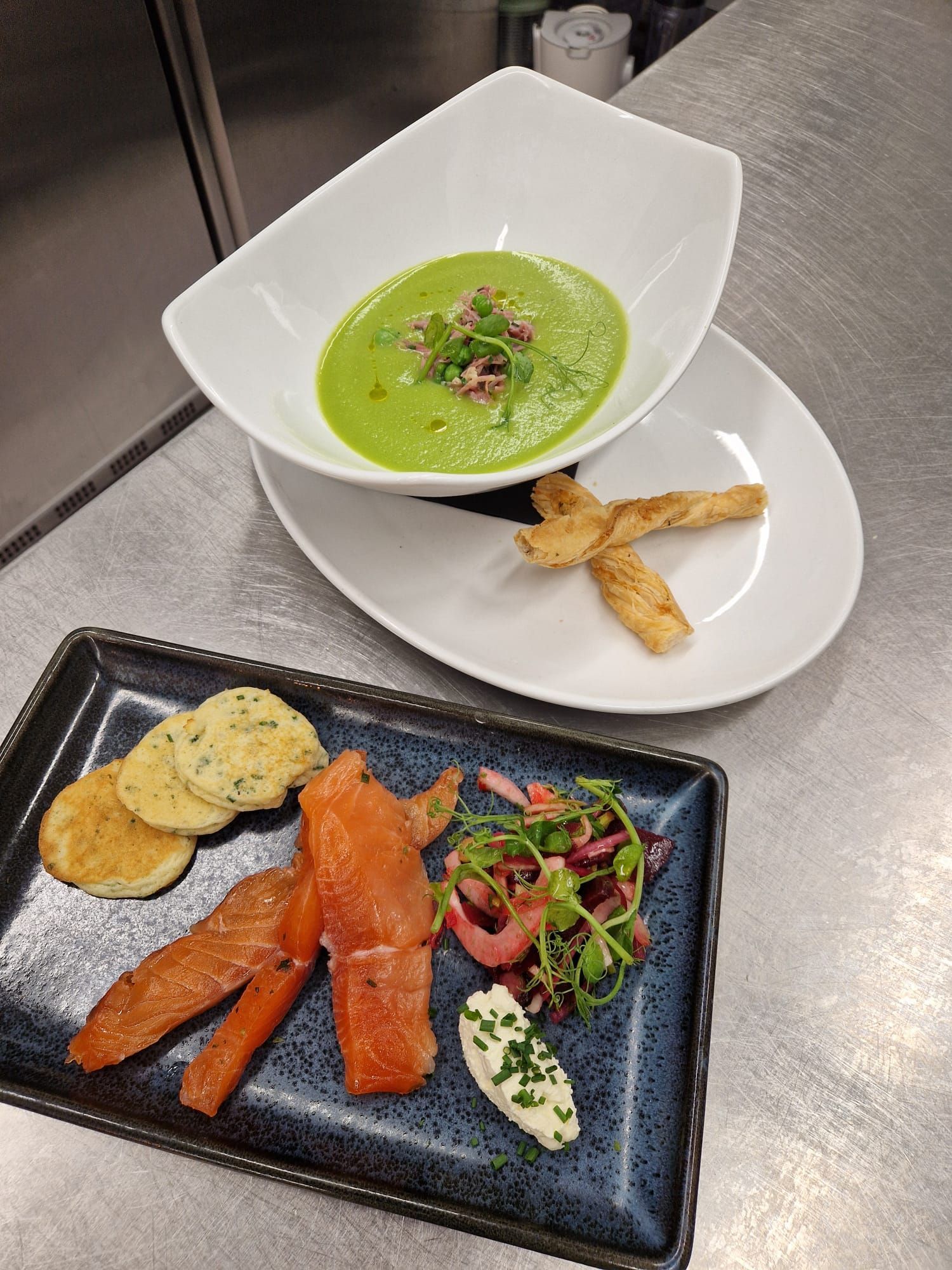 A bowl of garden pea soup with truffle oil and a plate of gin-cured salmon