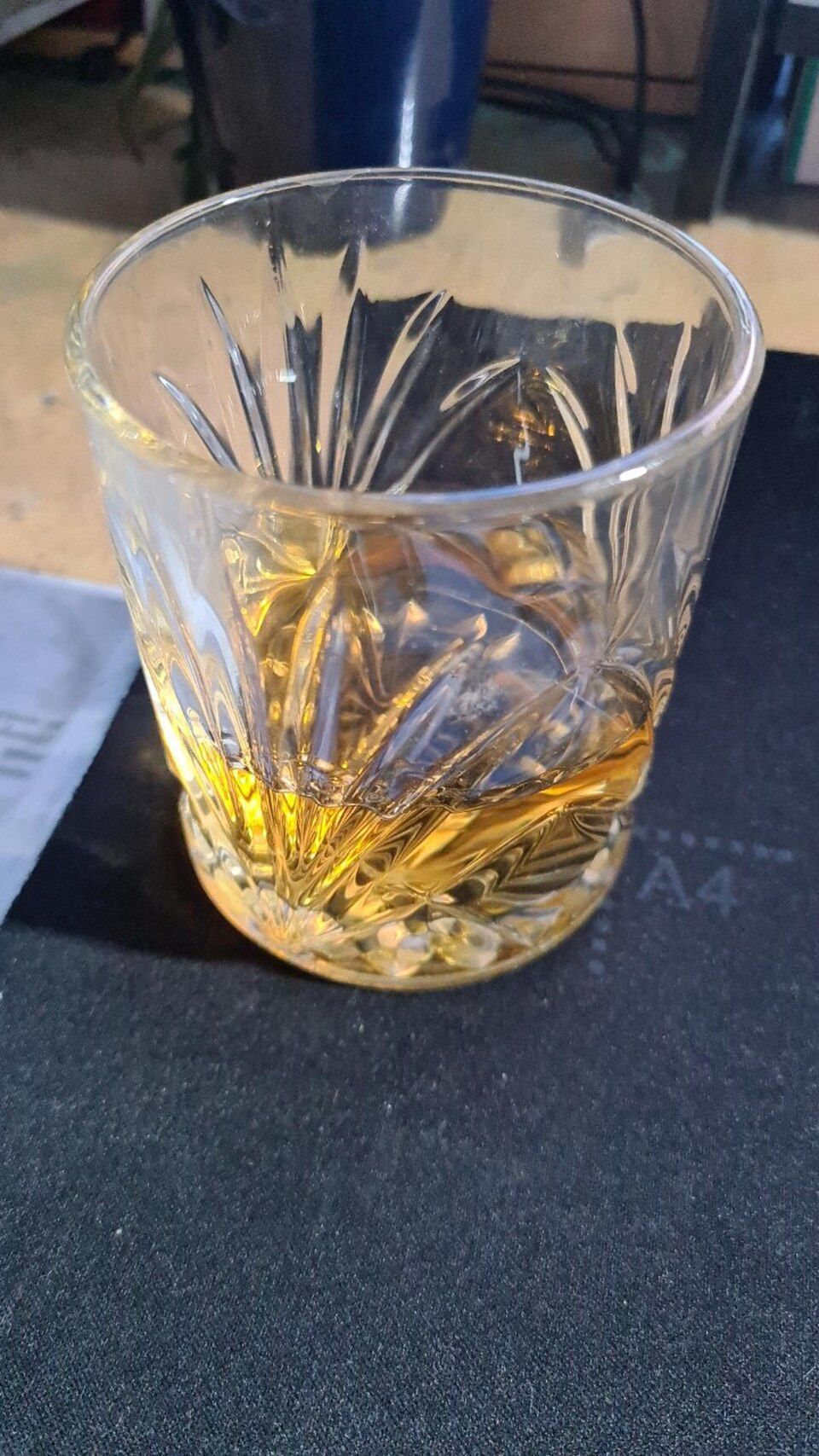 A glass with an amber liquid, whisky, in it.